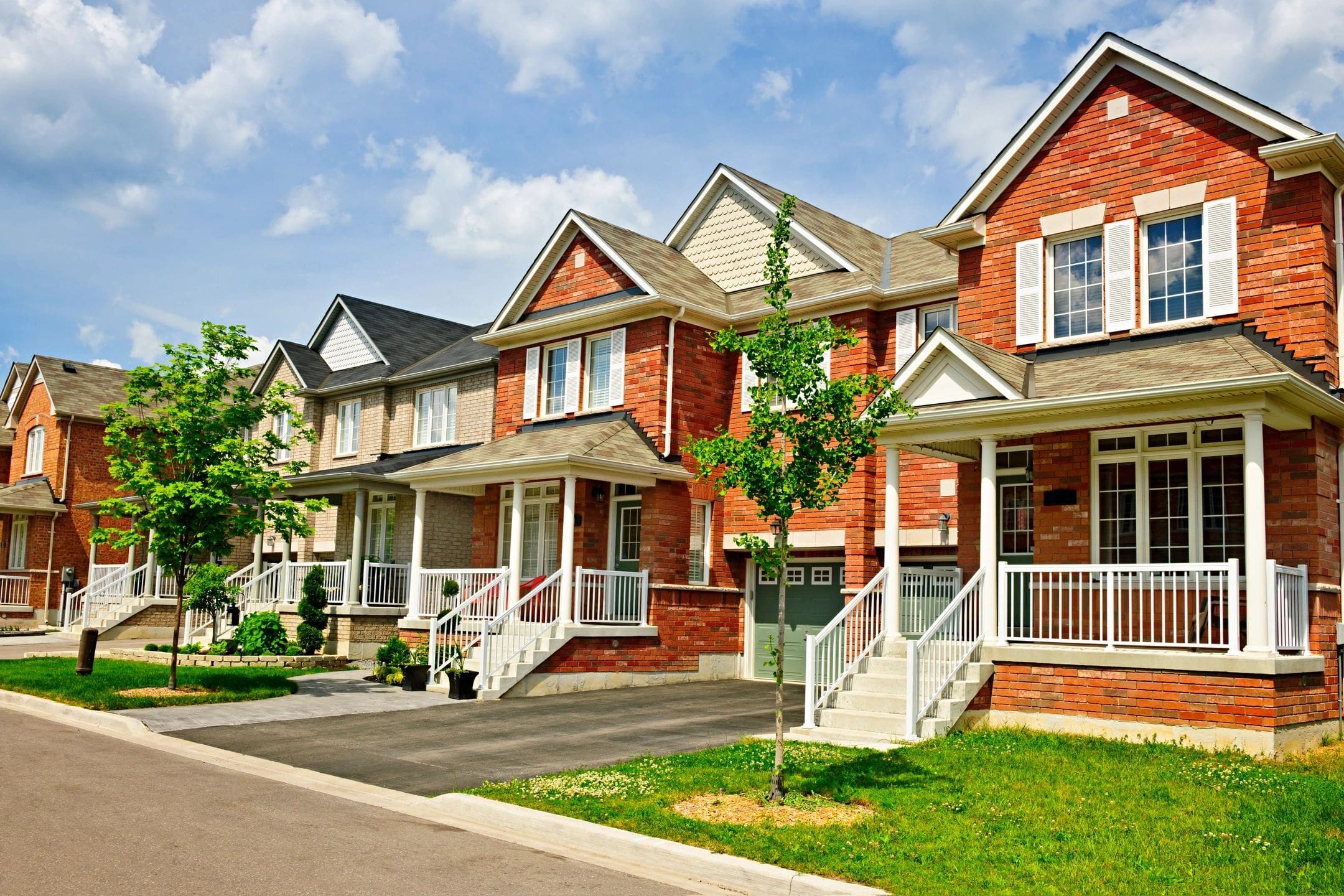 A row of houses with steps leading to the front door.